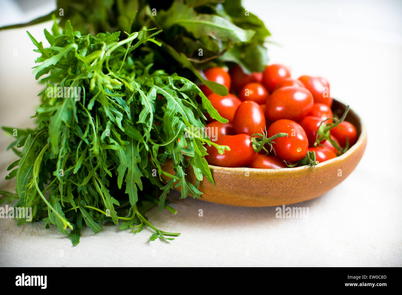 Grüner Salat und rote Tomaten roh auf Platte auf neutralem Hintergrund Stockfoto