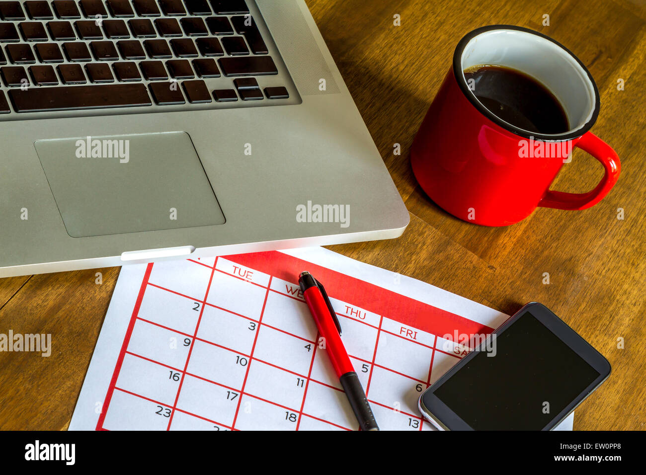 Arbeiten mit dem Laptop und Organisation von monatlichen Aktivitäten und Termine im Kalender Stockfoto