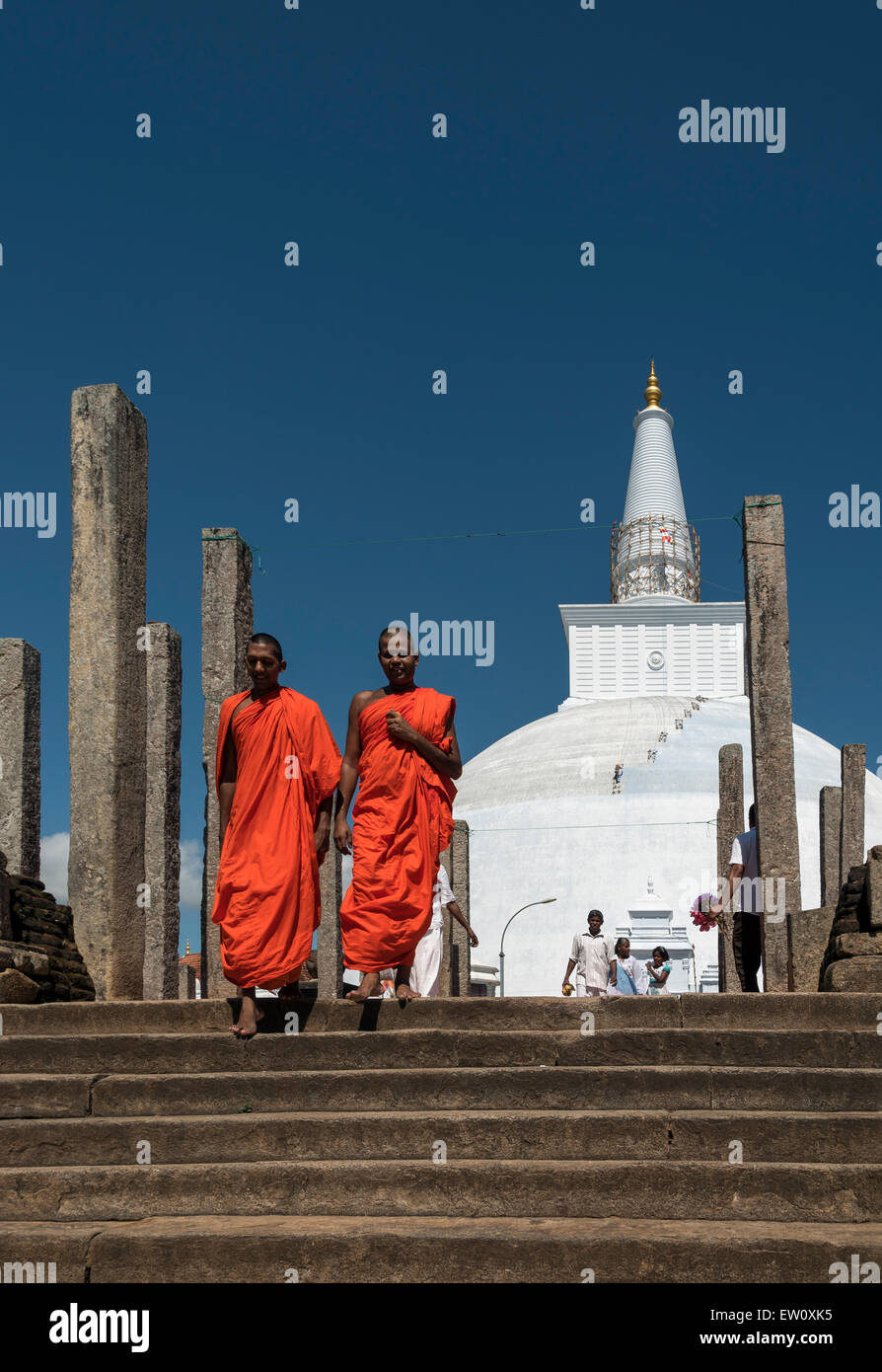 Buddhistische Mönche in Safran Roben außerhalb Ruwanwelisaya (Ruwanweli Maha Seya) Stupa, Anuradhapura, Sri Lanka Stockfoto
