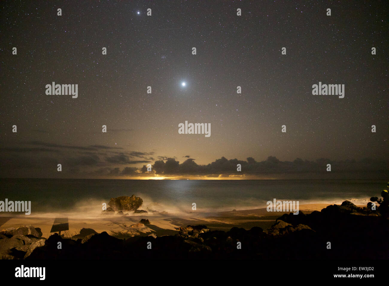 Am Nachthimmel gesehen von der West Küste von Molokai, Blick auf Oahu und Honolulu.  Das helle Objekt in der Mitte ist die Venus. Stockfoto