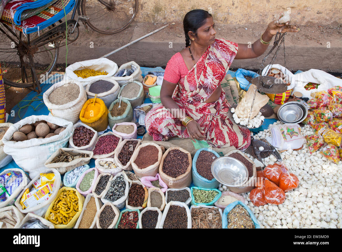 Ein Markt-Verkäufer benutzt Skalen Knoblauch auf dem Gewürzbasar in Hospet wiegen Stockfoto