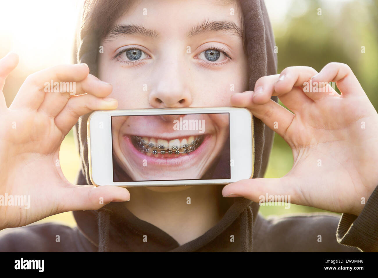virtuelle Immobilien, Teenager, die eine Smartphone vor seinem Gesicht halten Stockfoto