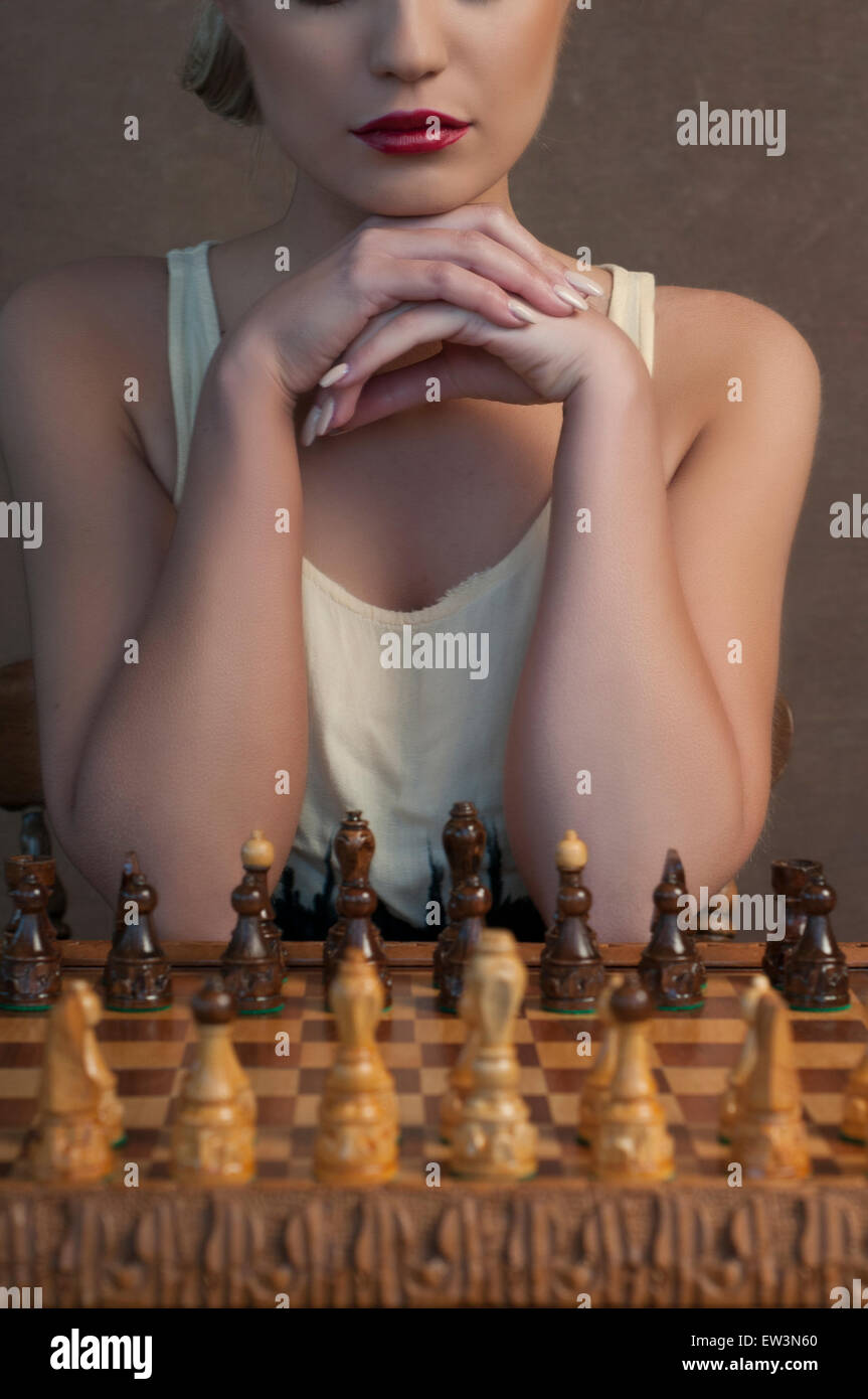 Schöne junge Frau, die Schach spielen Stockfoto