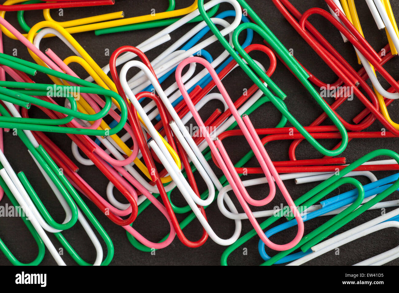 Büroklammern auf schwarzem Hintergrund Stockfoto