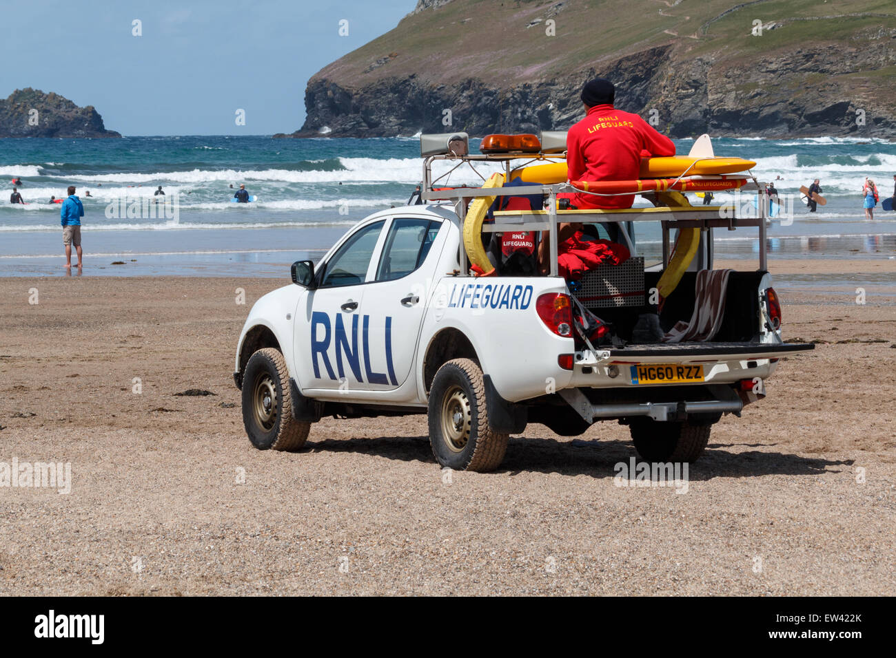 Rettungsschwimmer aus der RNLI beobachten Surfer und Bodyboarder Polzeath Strand, Cornwall, UK. Stockfoto