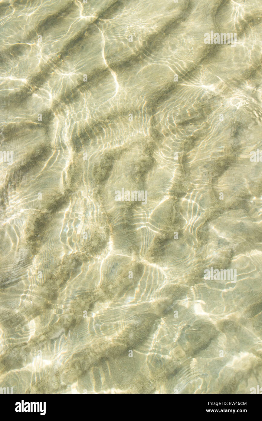 transparentes Wasser plätschern, Sand Wellen und Sonnenlicht blendet. Ozean-Boden-Hintergrund Stockfoto