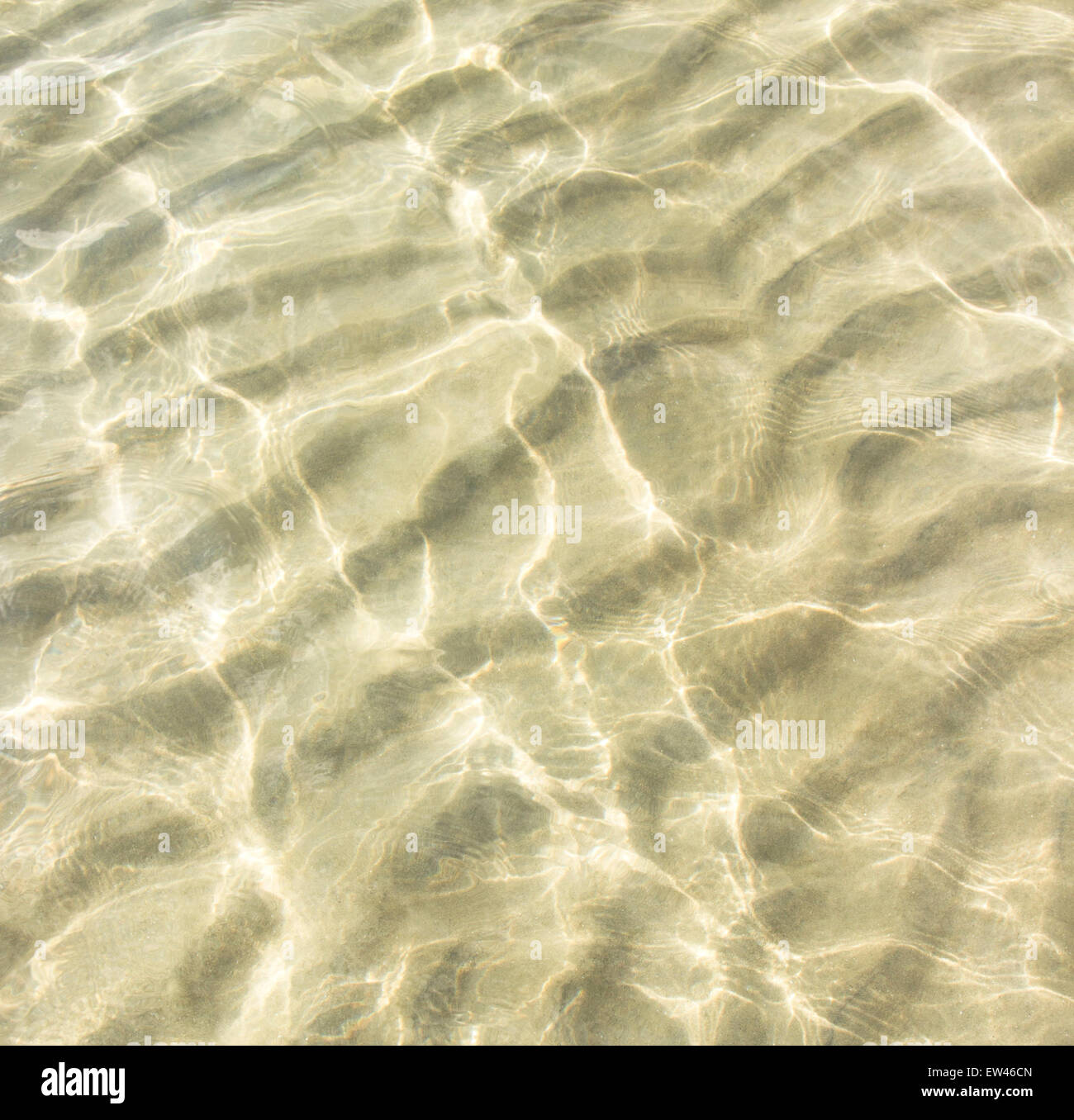 transparentes Wasser plätschern, Sand Wellen und Sonnenlicht blendet. Meeresboden Hintergrund Stockfoto