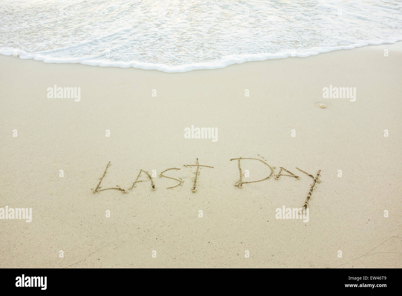 Eine Nachricht, letzter Tag, geschrieben in den Sand am Strand einer tropischen Insel. Traurigkeit ist Konzept. Stockfoto