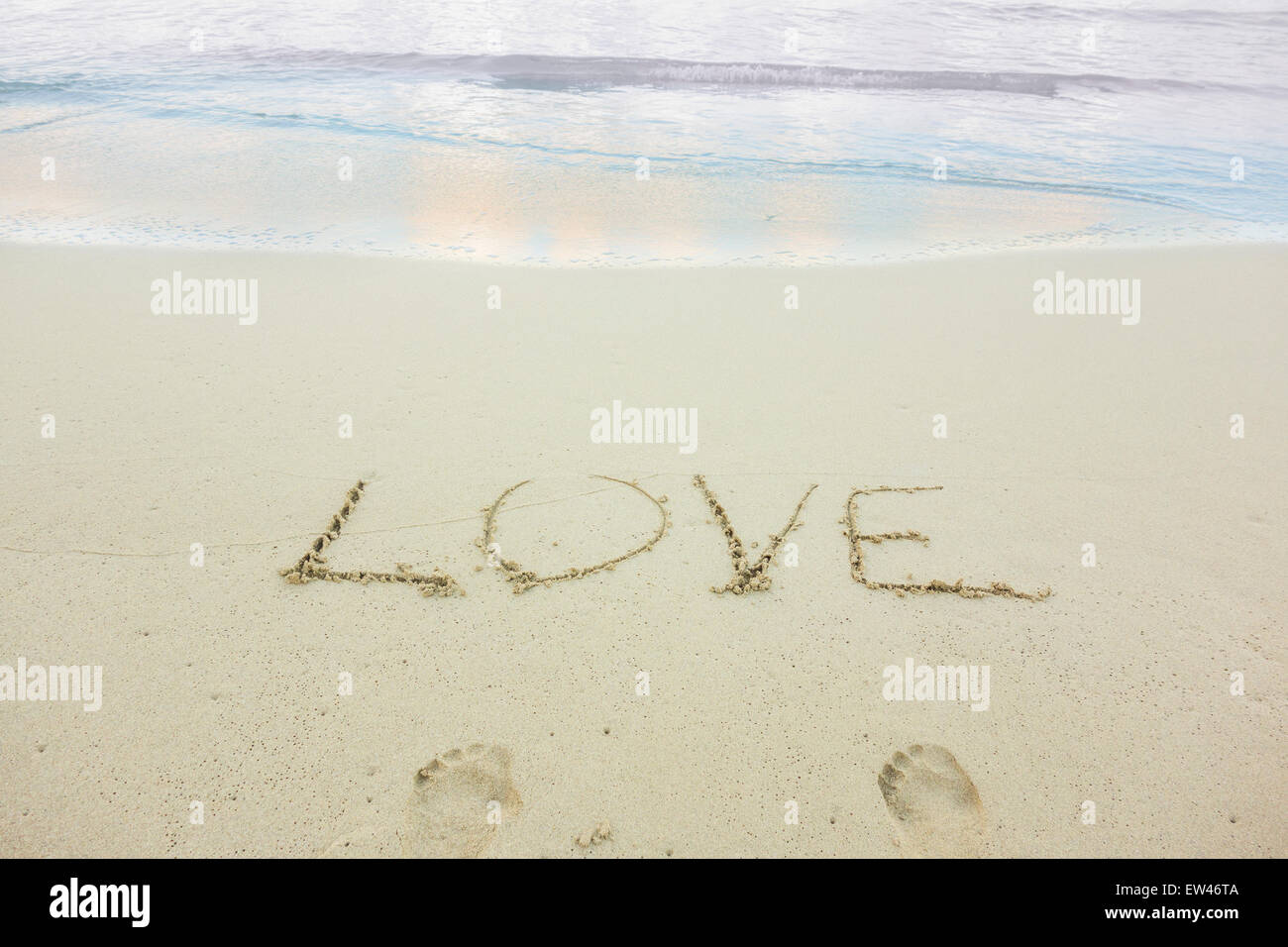 Eine Nachricht, Liebe, geschrieben in den Sand am Strand einer tropischen Insel. Konzeptionelle. Stockfoto