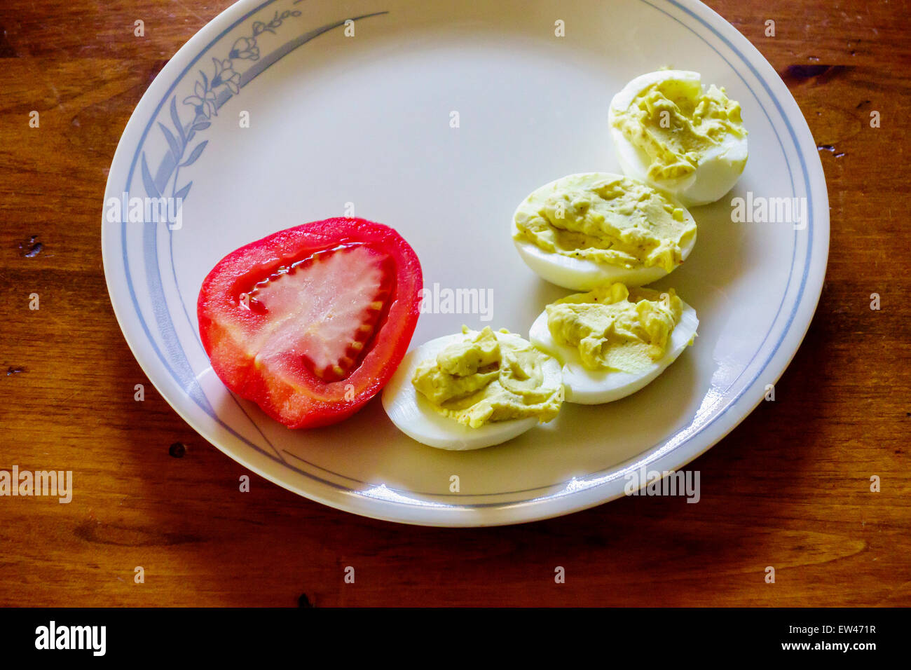 Die Hälfte der Roma-Tomaten auf einem Teller mit deviled Eiern. Stockfoto