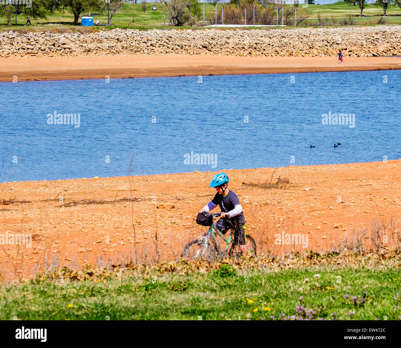 Ein Junge fährt mit dem Fahrrad auf einem trockenen Flußbett am See Hefner während einer Dürre in Oklahoma City, Oklahoma. Stockfoto