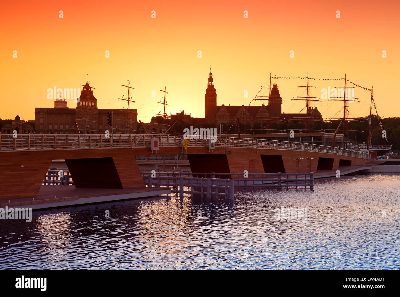 Sonnenuntergang über der Skyline von Szczecin (Stettin) mit Silhouetten von Gebäuden und Schiffen, Polen. Stockfoto