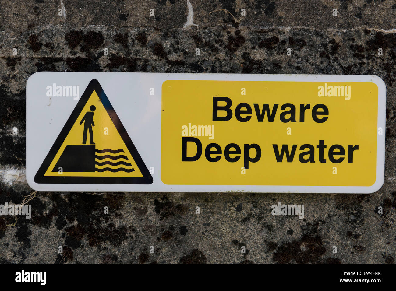 Ein Schild warnt "Hüten Sie sich vor der Tiefenwasser" in der Nähe von einem See. Stockfoto