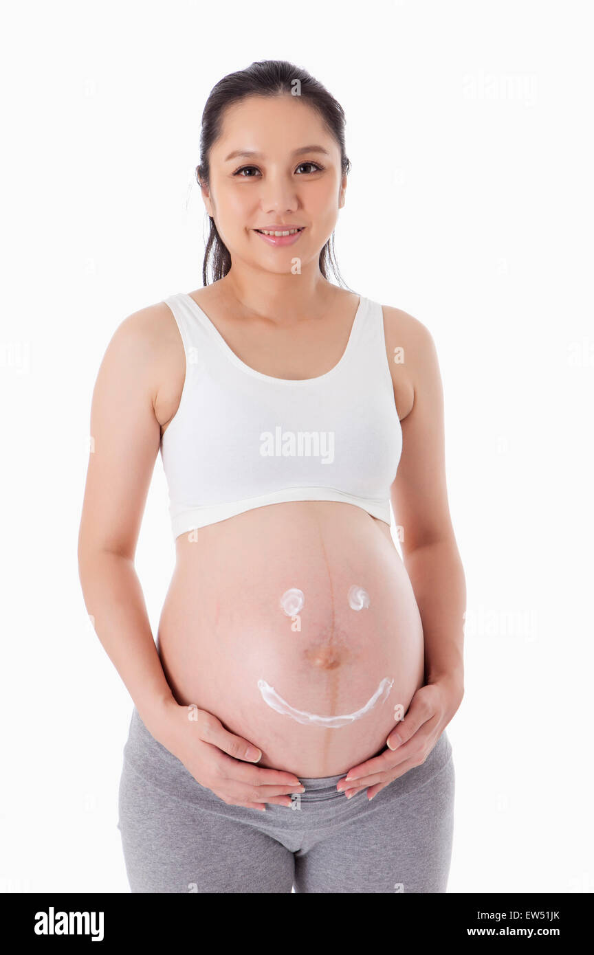 Ein lächelndes Gesicht auf schwangere Frau Bauch Stockfoto