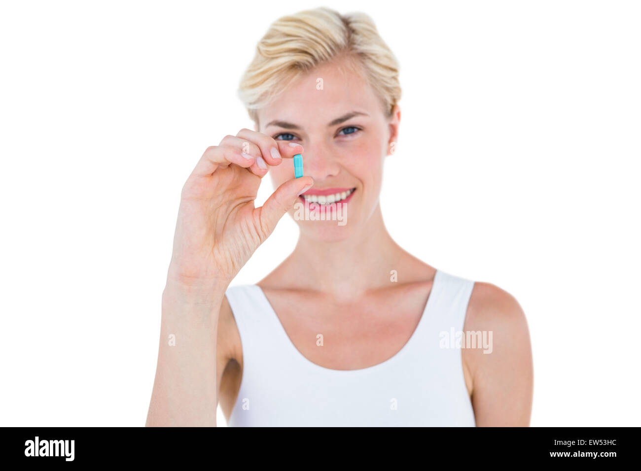 Lächelnde blonde Frau, die blaue Pille Stockfoto