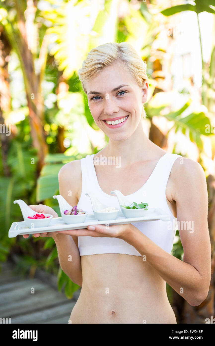 Glücklich blonde Frau Halteplatte mit Kräutermedizin Stockfoto