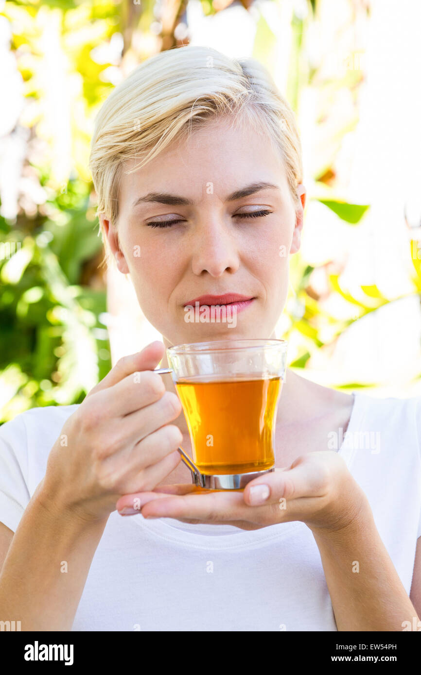 Attraktive blonde Frau mit Glas Tee Stockfoto
