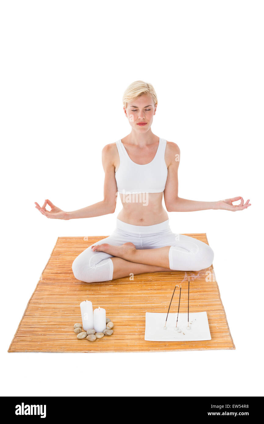 Fit Woman meditieren auf Bambusmatte Stockfoto
