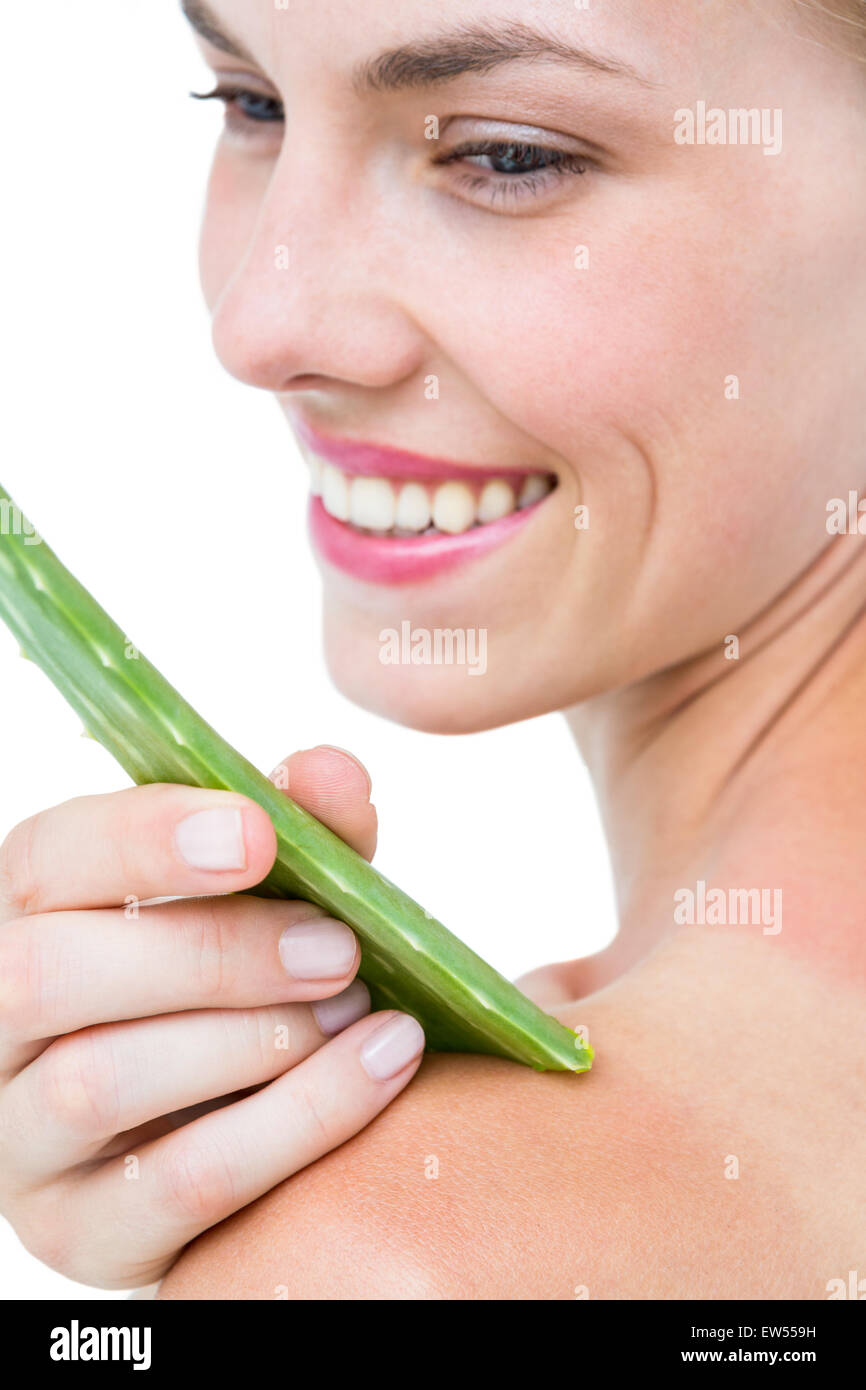 Attraktive Frau, die Feuchtigkeit ihrer Haut mit Aloe Vera Blatt Stockfoto