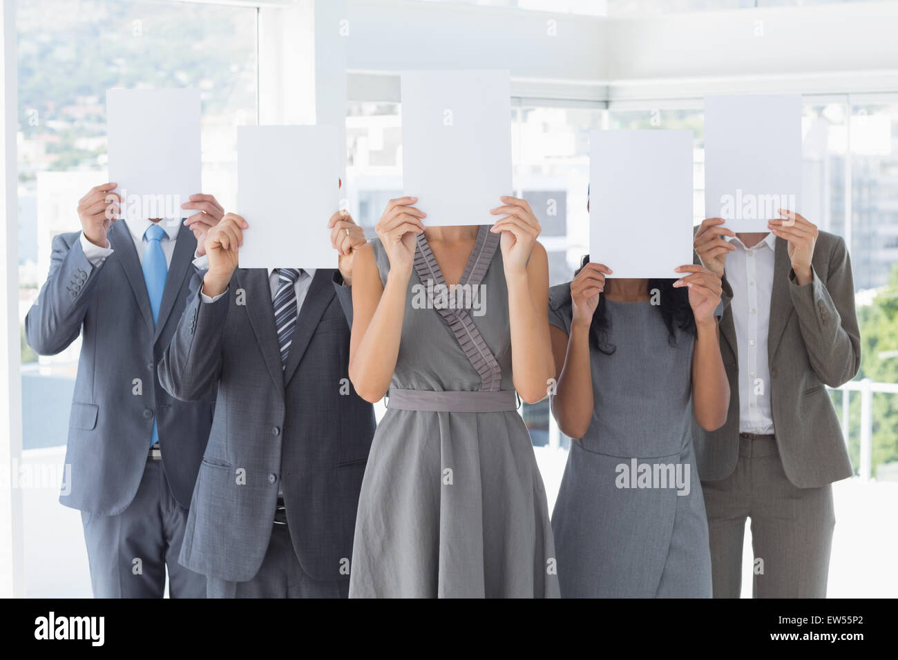 Geschäftskollegen versteckt ihr Gesicht mit Papier Stockfoto