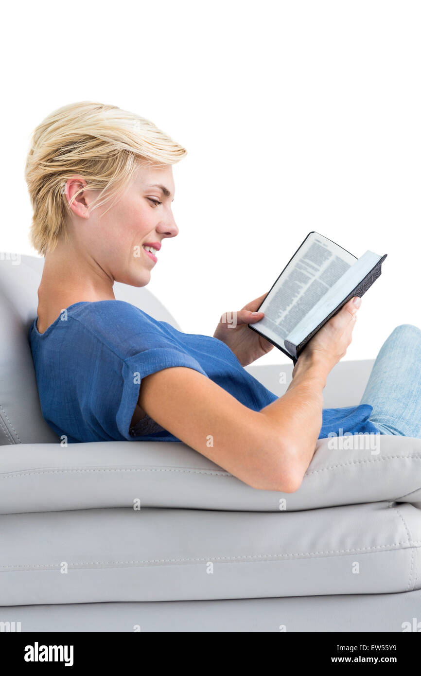 Attraktive blonde Frau, die ein Buch auf der couch Stockfoto