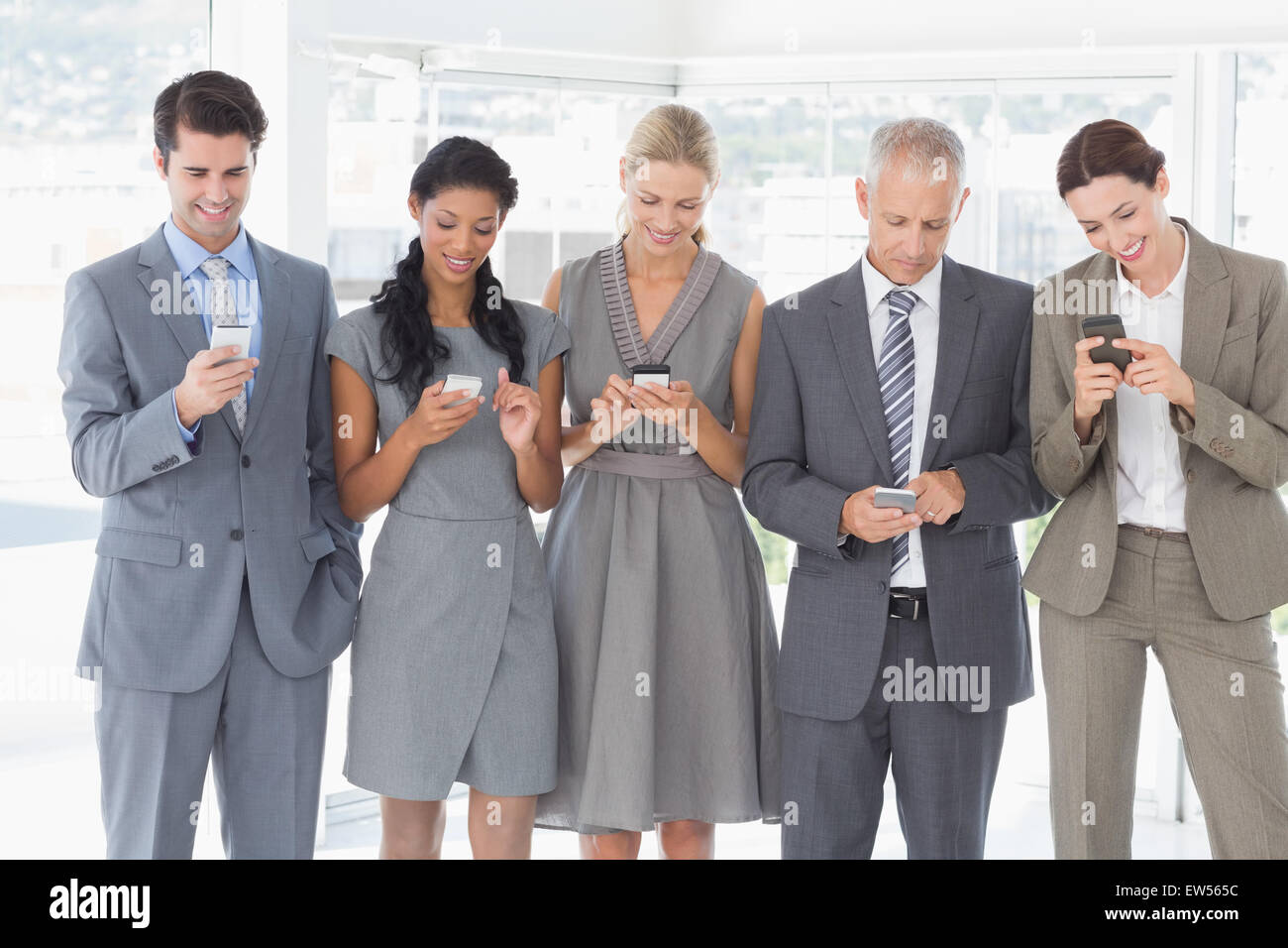 Mitarbeiter nutzen ihr Mobiltelefon Stockfoto