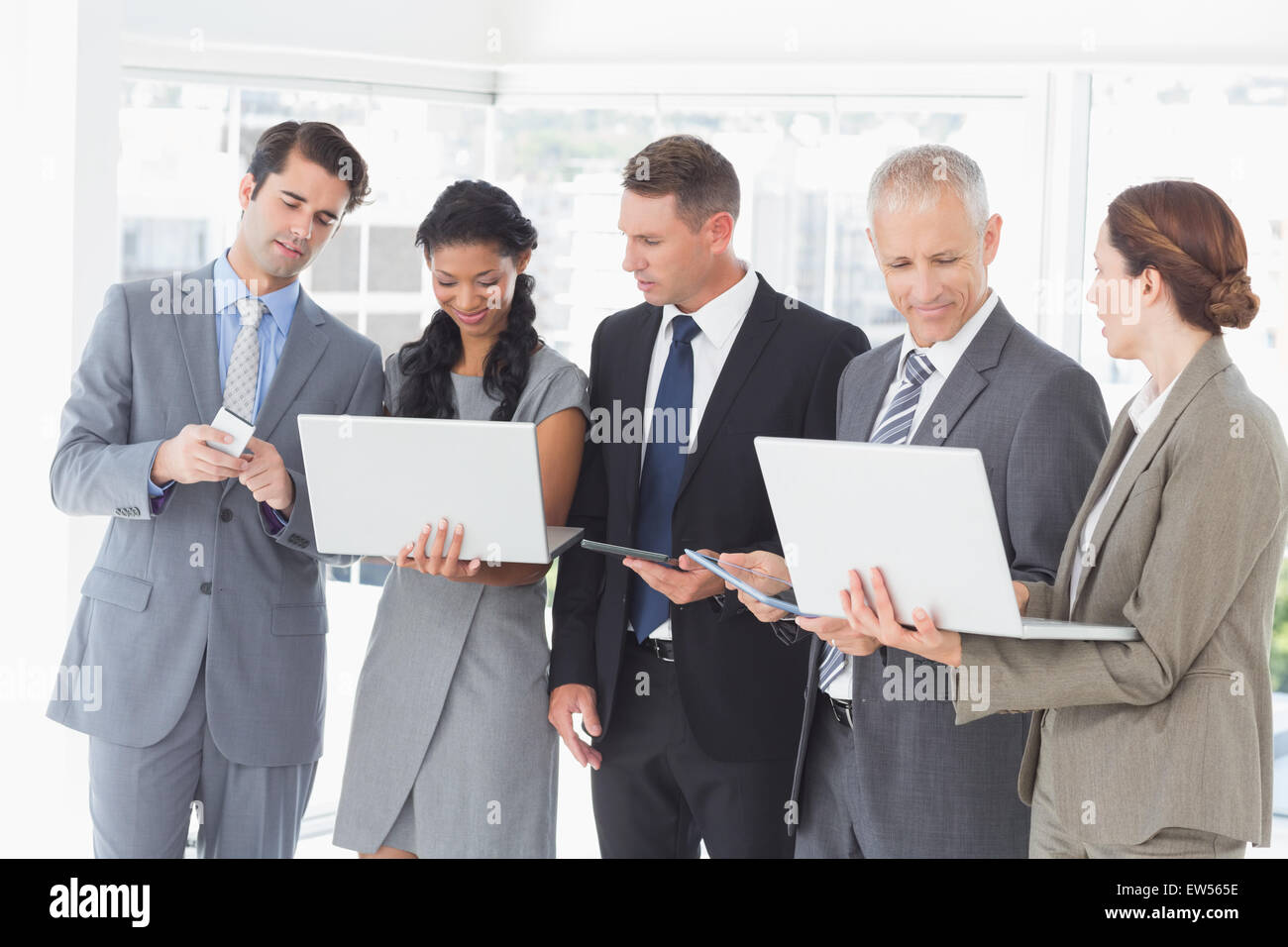 Geschäftskollegen zeigen ihre Multimedia-Geräte miteinander verbunden Stockfoto