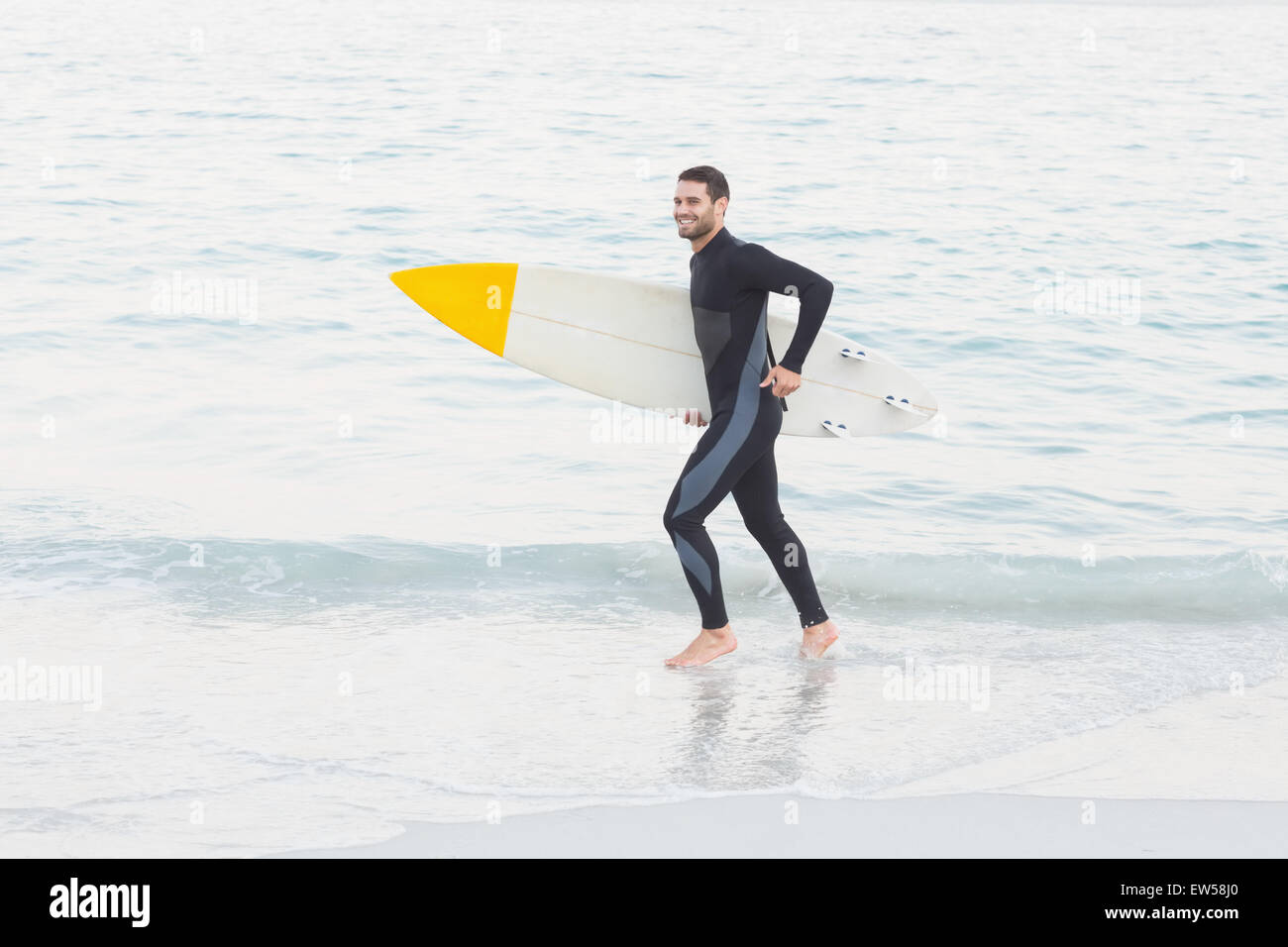 Mann im Anzug mit einem Surfbrett an einem sonnigen Tag Stockfoto