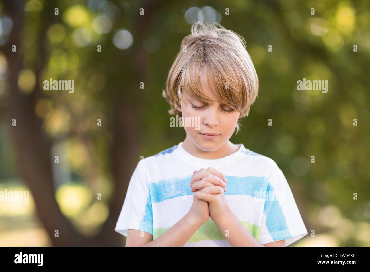 Kleiner Junge seine Gebete zu sagen Stockfoto