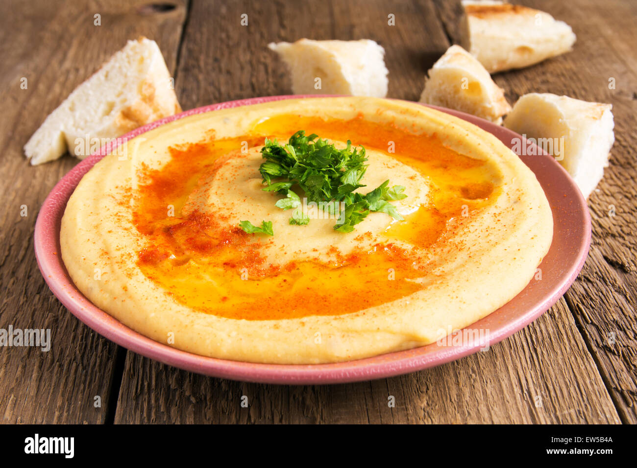 Hummus mit Petersilie und Pita Brot auf Teller und rustikalen hölzernen Hintergrund hautnah Stockfoto