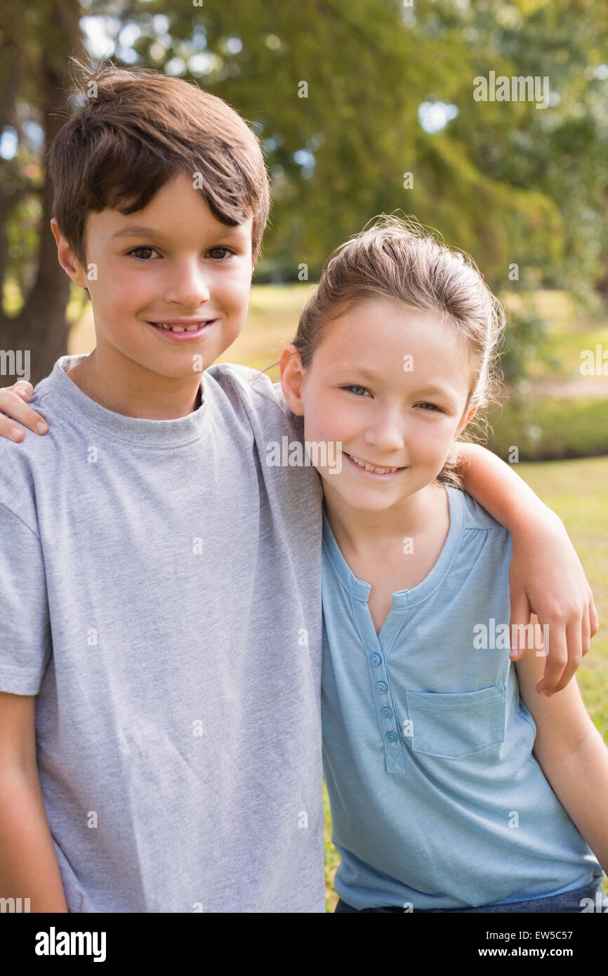 Lächelnde Geschwister Blick in die Kamera im park Stockfoto