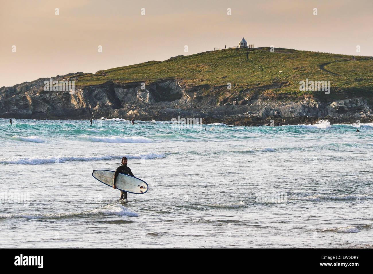 Ein Surfer zu Fuß aus dem Meer am Fistral Beach in Newquay, Cornwall. VEREINIGTES KÖNIGREICH. Stockfoto