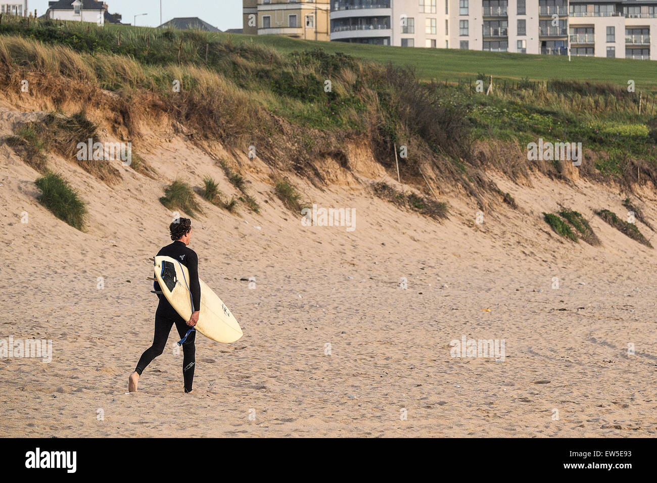 Ein Surfer zu Fuß auf den Fistral Beach in Newquay, Cornwall. Stockfoto