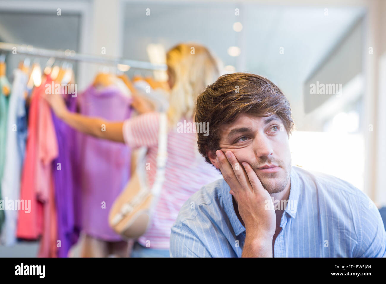 Glücklich blonde Frau mit ihrem erschöpften Freund einkaufen zu tun Stockfoto