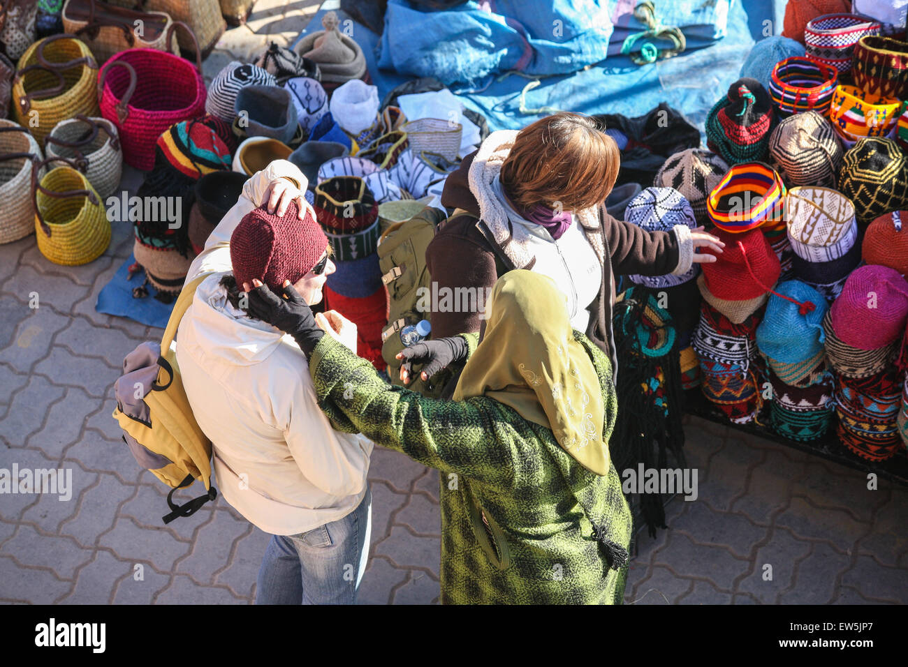 Einheimische Frau Verkäufer Hüte bekommt ein Tourist auf ihre waren, unter den Handarbeiten und Andenken waren für den Verkauf in diesem man versuchen Stockfoto