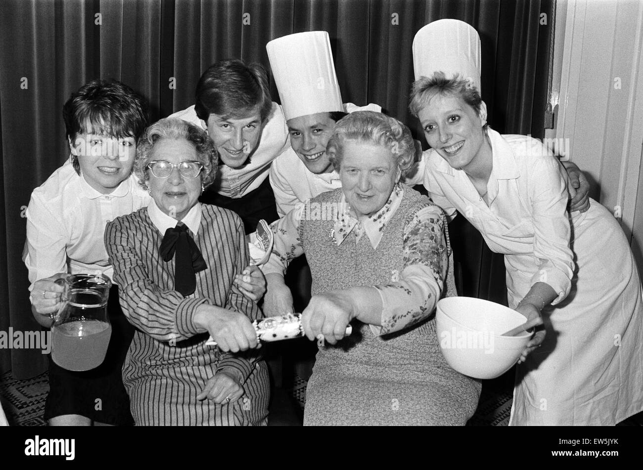 Versprechen eine Rissbildung gute Zeit als Southgate Mieter Verein Vorsitzender Frau Marjorie Drake und Sekretärin Miss Ivy Bailey (rechts), Huddersfield Polytechnischen catering Studenten treffen. Der Caterer statt Spendenveranstaltungen ermöglichen eine frühe Weihnachten dinne Stockfoto