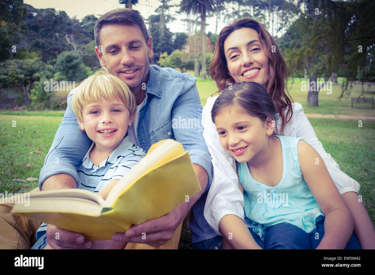 Glückliche Familie ein Buch im park Stockfoto