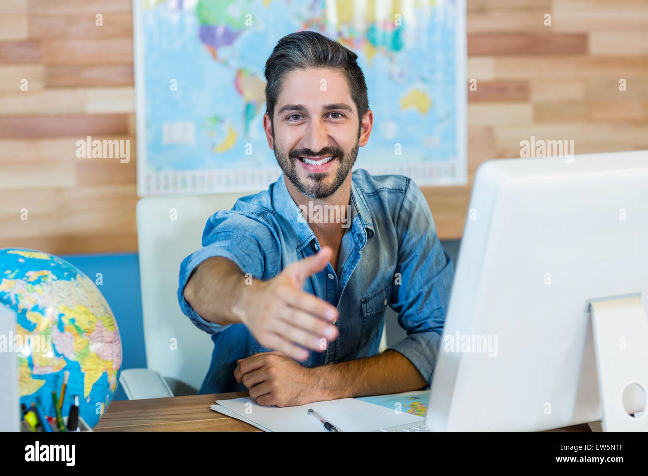 Lächelnde Reisebüro präsentiert seine hand Stockfoto