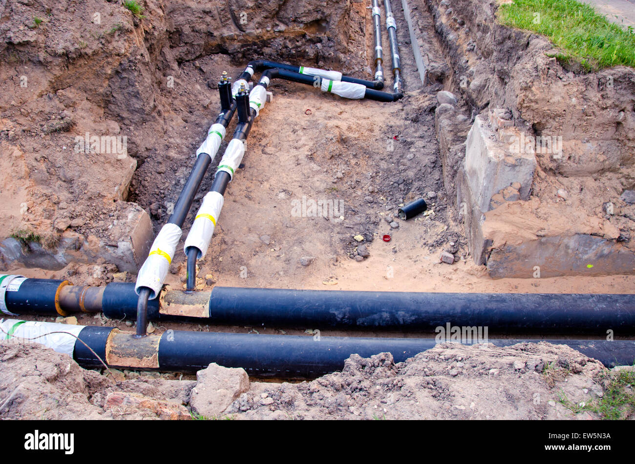 moderne Kunststofftechnik schwarz Heizungsrohre im Graben in der Nähe von Stadthaus Stockfoto