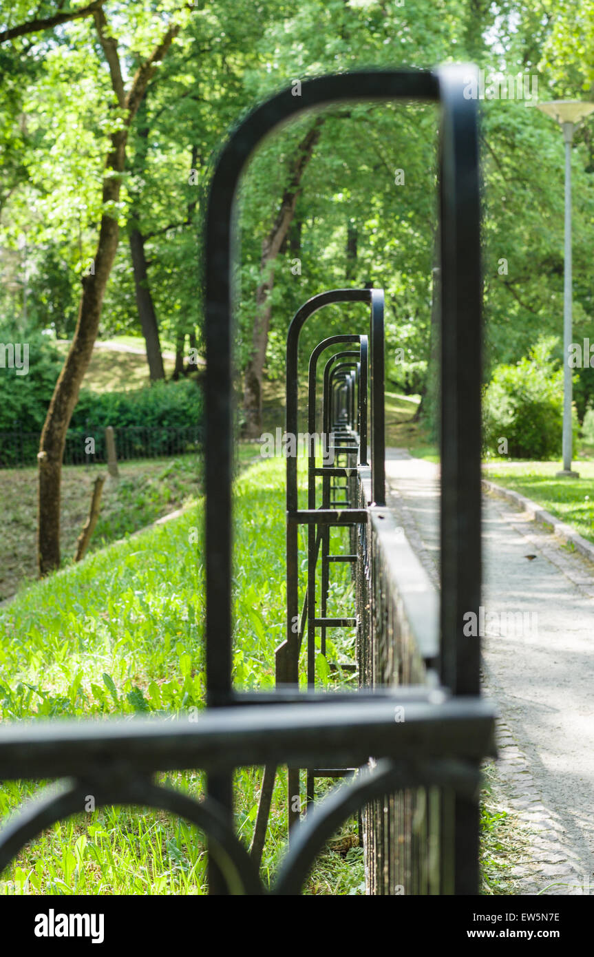 Abstrakte verschwindenden dekorativen Schmiedeeisen Zaun im Sommerpark Stockfoto