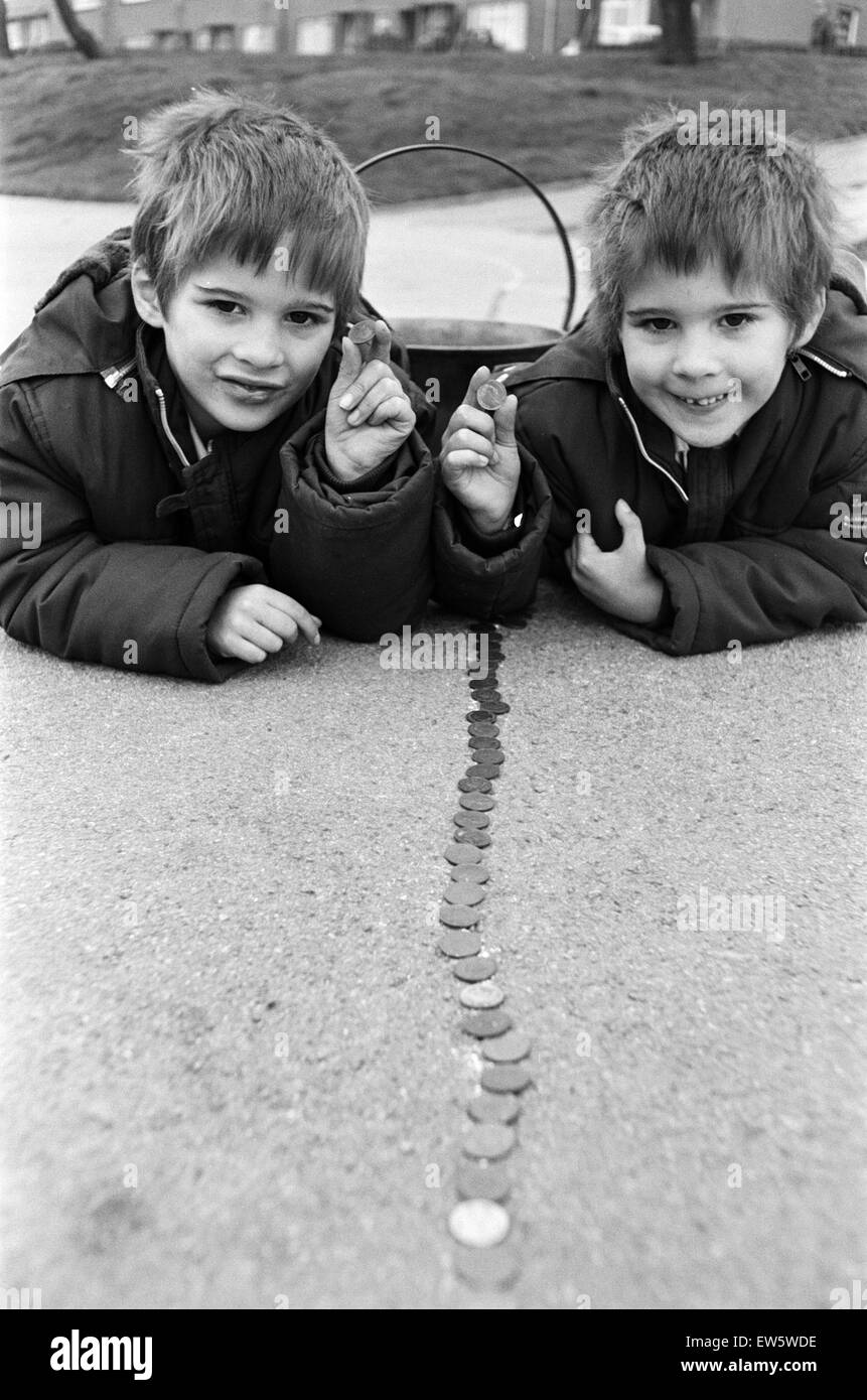 Wenn Sie bis hin zu IT. fünfjährigen Zwillinge Simeon und Peter Yianni trotzte der Kälte zu helfen, eine Linie von Pfennigen erstreckt sich rund um den Schulhof zu vervollständigen. Alle 256 Schülerinnen und Schüler der Reinwood Kind und Kindergarten, Huddersfield, erfasst ihre s Stockfoto