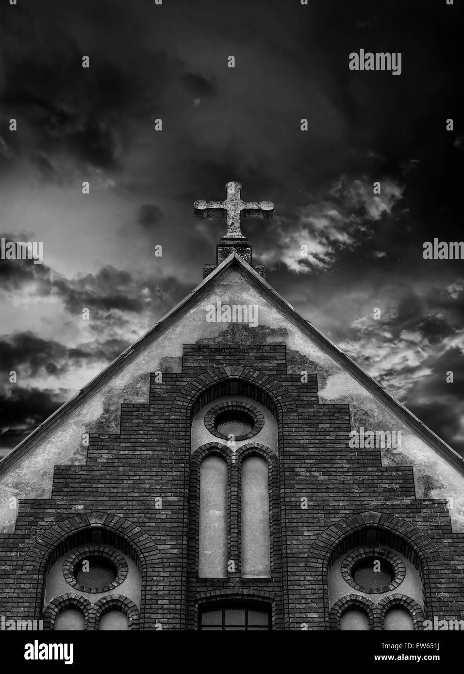 Kreuz auf das Kirchendach mit Wolken hinter. Stockfoto