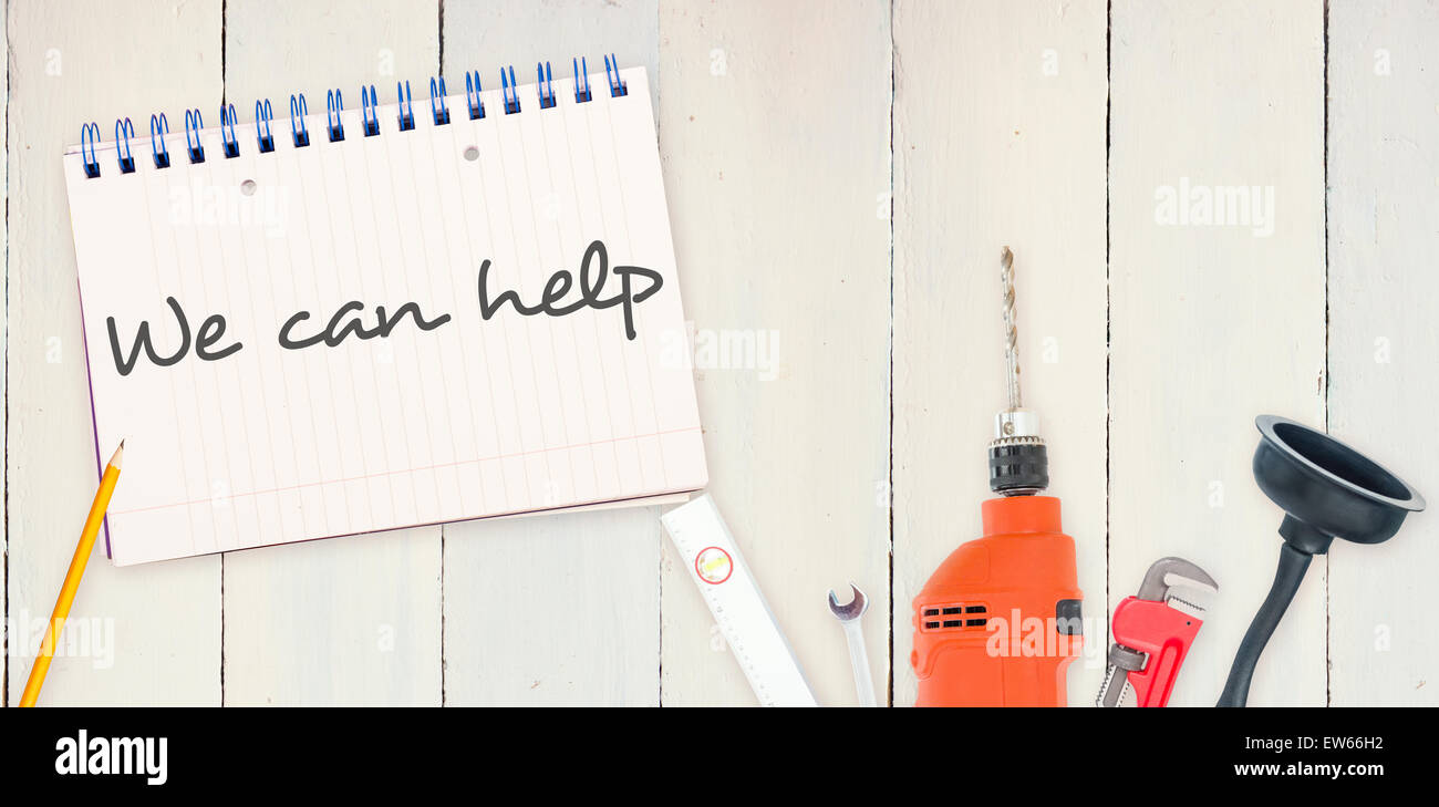 Wir helfen gegen Werkzeuge und Notizblock auf hölzernen Hintergrund Stockfoto