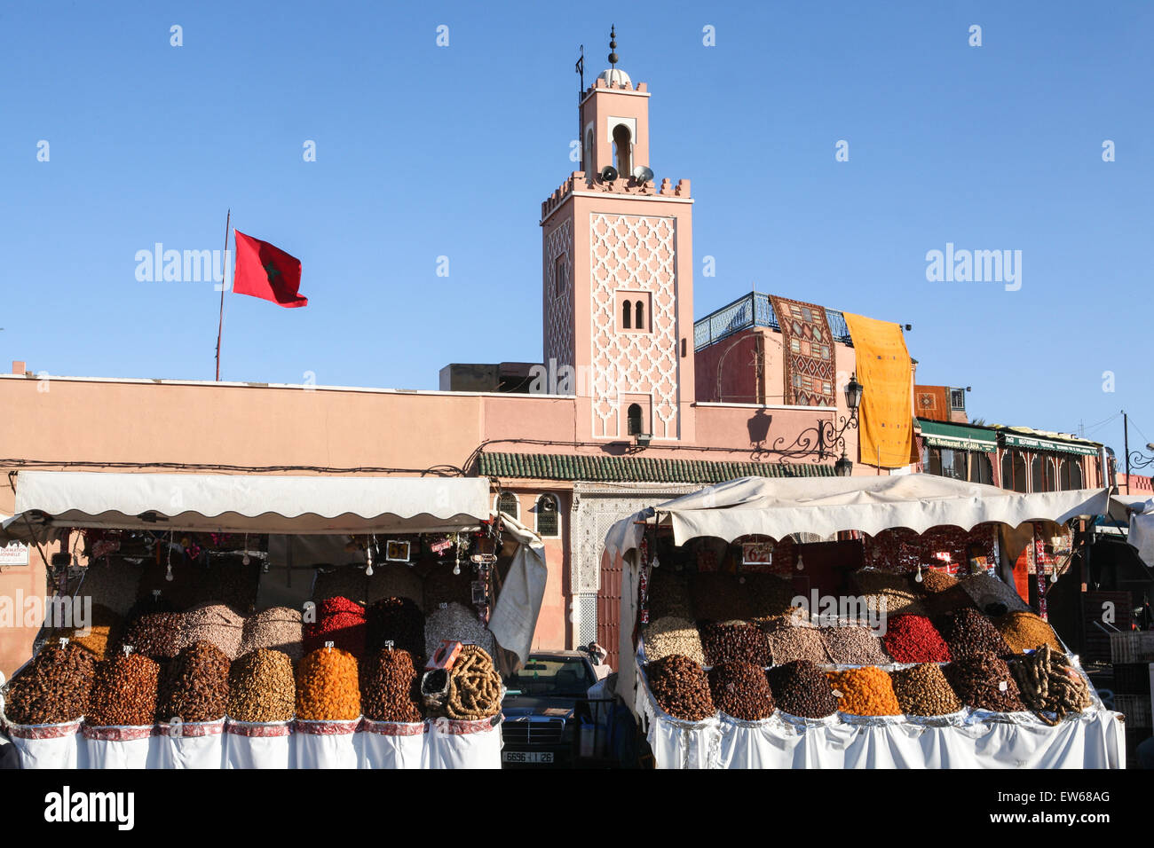 Früchte und Nüsse für Verkauf an dieser Straße auf, Djemaa, Djamaa El Fna, dem Hauptplatz in Marrakesch mit Moschee im Hintergrund, Marrak Stockfoto