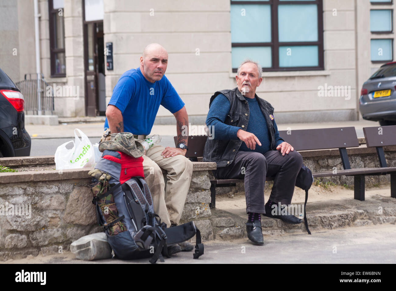 Zwei Männer saßen am Strand von Weymouth, Dorset im Juni im Gespräch Stockfoto