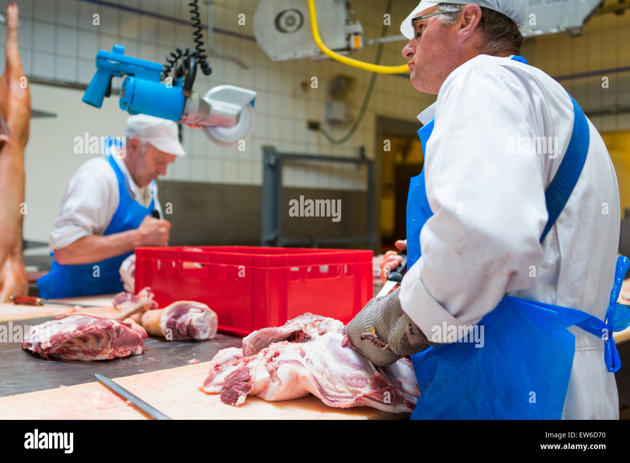 Zwei Metzger bei der Arbeit mit Schweinefleisch in der Metzgerei Stockfoto