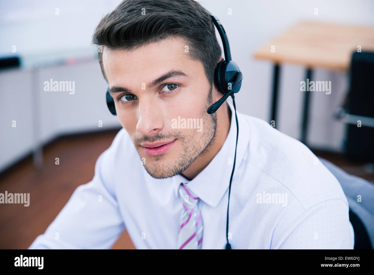 Porträt eines schönen männlichen Betreiber mit Kopfhörer Blick in die Kamera im Büro Stockfoto