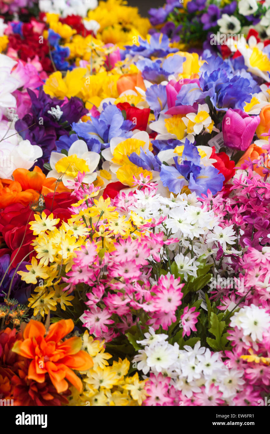Kunstkunststoffblumen zum Verkauf am Marktstand in Dorchester, Dorset, Großbritannien im Juni Stockfoto