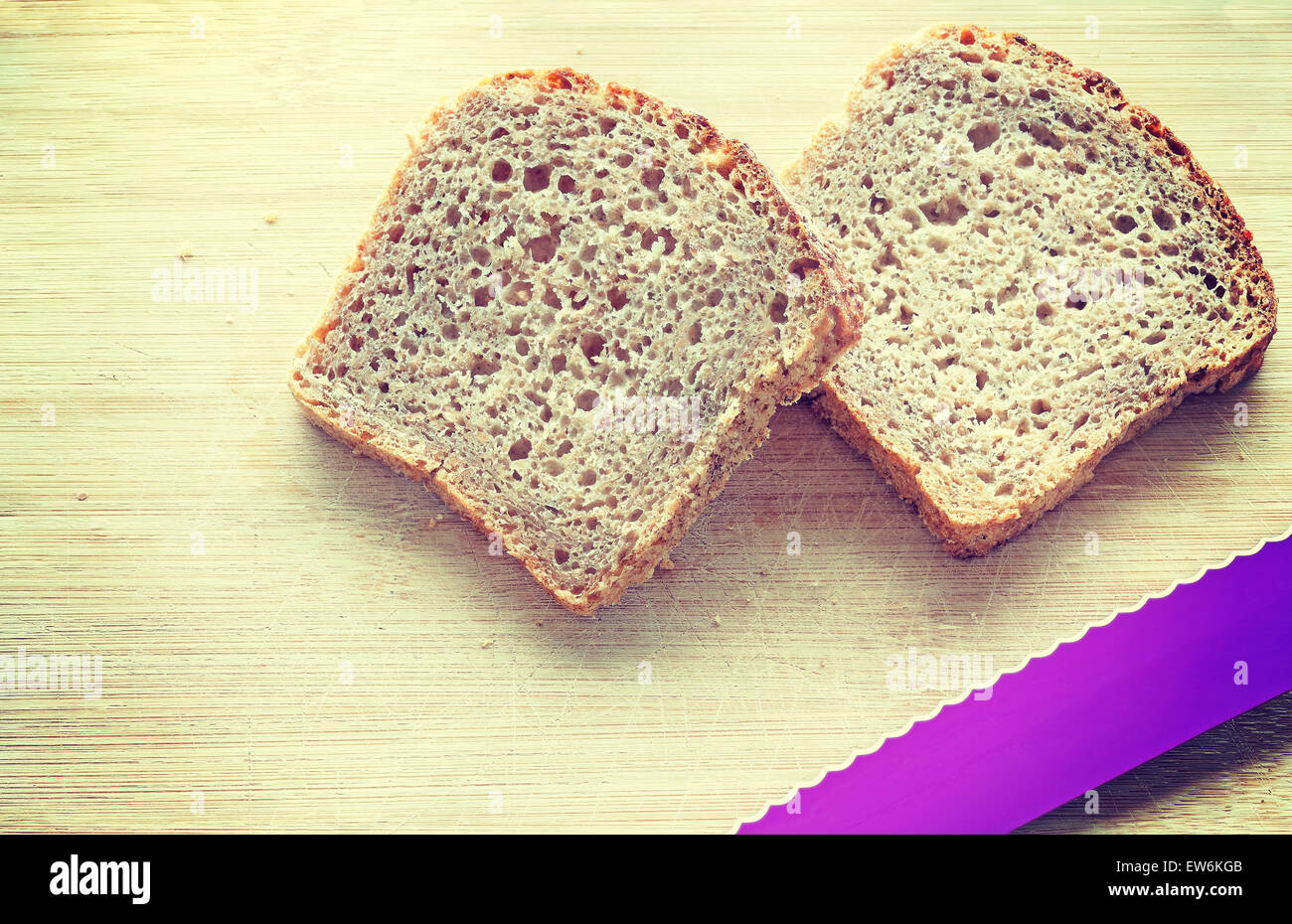 Retro Vintage getönten zwei Scheiben Vollkornbrot und ein Messer auf Bambus-Tisch. Stockfoto