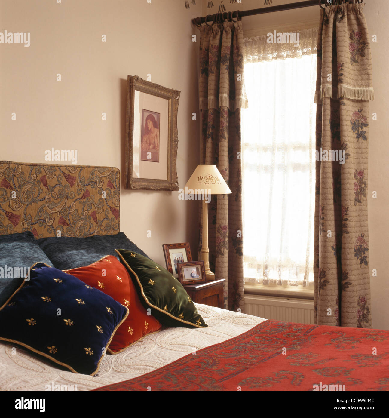 Samtkissen auf Polsterbett in kleinen neunziger Jahren mit braun gemusterten Gardinen Schlafzimmer Stockfoto